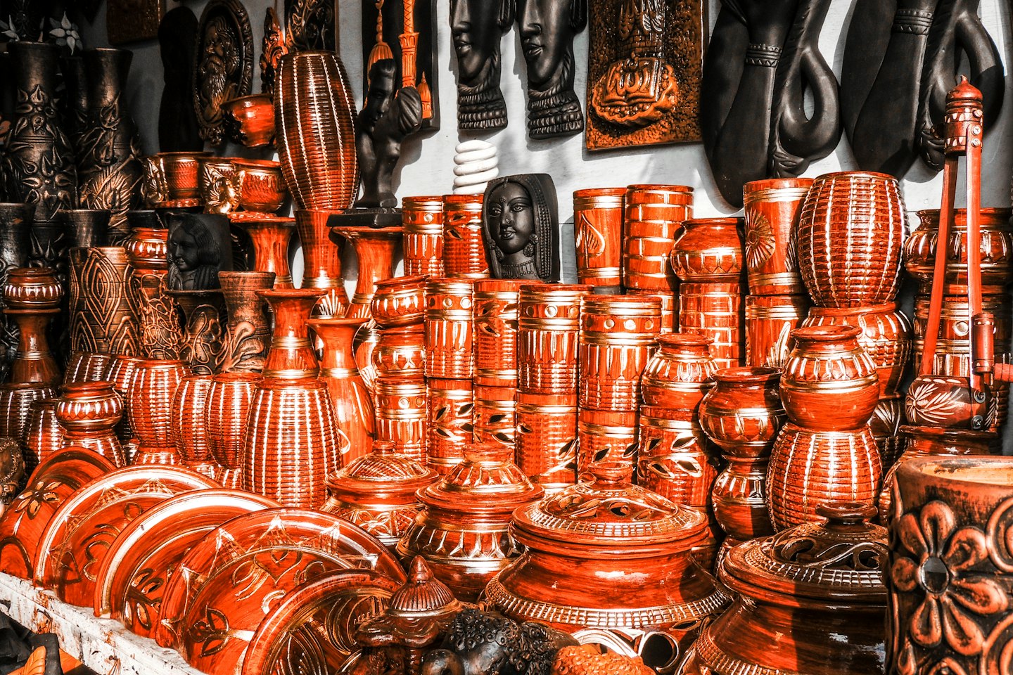 Artesanía de cerámica de terracota y objetos decorativos en una estantería.